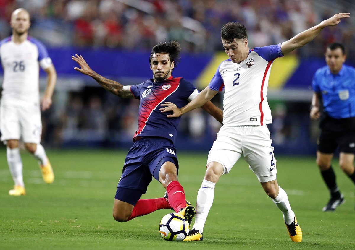 Bryan Ruiz, de Costa Rica, pelea por el balón con Jorge Villafana, de EE.UU., en el partido de las semifinales de Copa Oro. (Foto Prensa Libre: EFE)