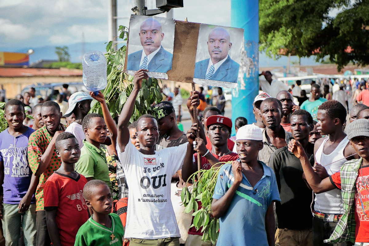 Partidarios del presidente de Burundi, Pierre Nkurunziza sostienen fotografías de él, durante su llegada a la capital, Bujumbura, Burund (Foto Prensa Libre:AP).