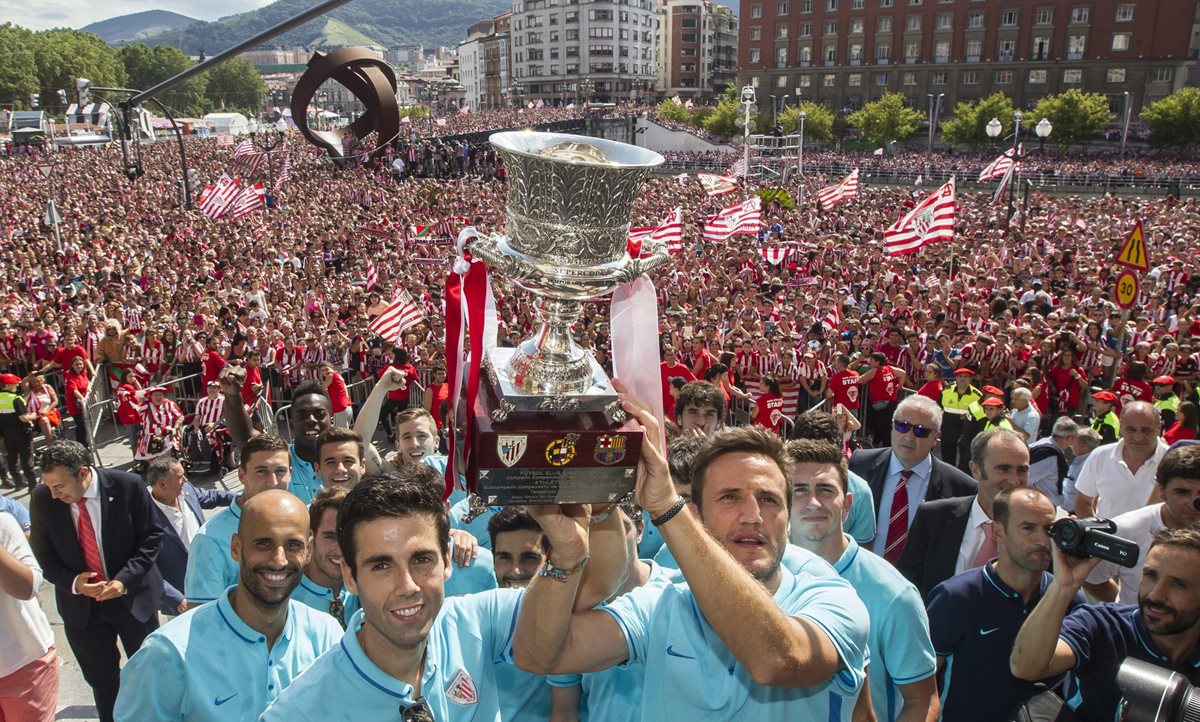 El capitán Carlos Gurpegui, sujeta el trofeo junto al resto de los jugadores del Athletic Club de Bilbao ante miles de personas que abarrotan la explanada del Ayuntamiento de Bilbao. (Foto Prensa Libre: EFE)