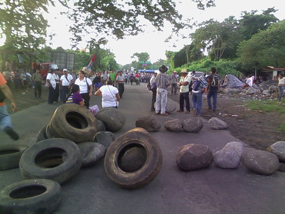 Campesinos utilizan piedras y llantas para impedir el paso de vehículos en Santa Cruz Muluá, Retalhuleu. (Foto Prensa Libre: Jorge Tizol)