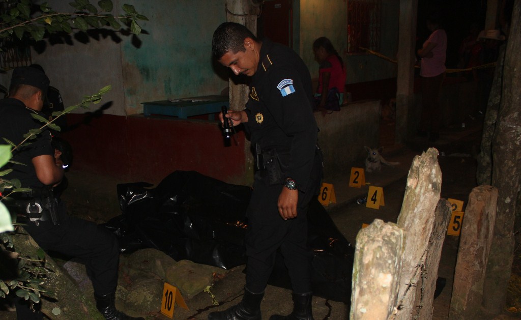 Agentes de la Policía Nacional Civil inspeccionan el lugar donde murió baleado Daniel Nufio, en Los Amates, Izabal. (Foto Prensa Libre: Edwin Perdomo)