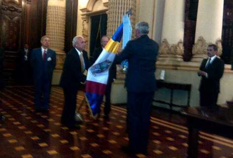 Mario Antonio Sandoval, presidente de la AGLE, porta la bandera de la institución para recibir la condecoración. (Foto Prensa Libre: Pamela Saravia)