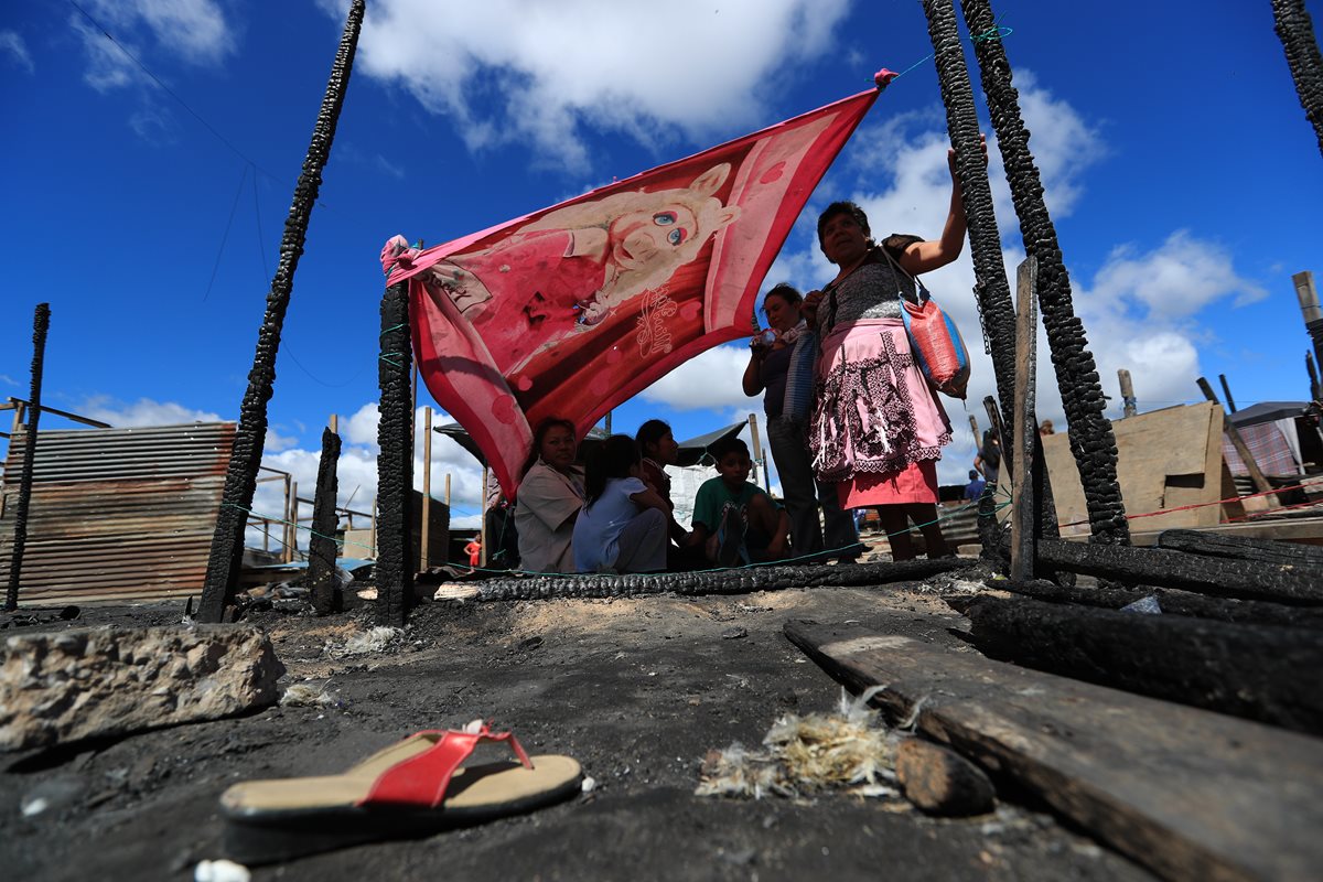 Miembros de una iglesia evangélica entregan alimentos a las familias damnificadas del asentamiento Los Pinos, en la zona 3.(Foto Prensa Libre: Carlos Hernández)