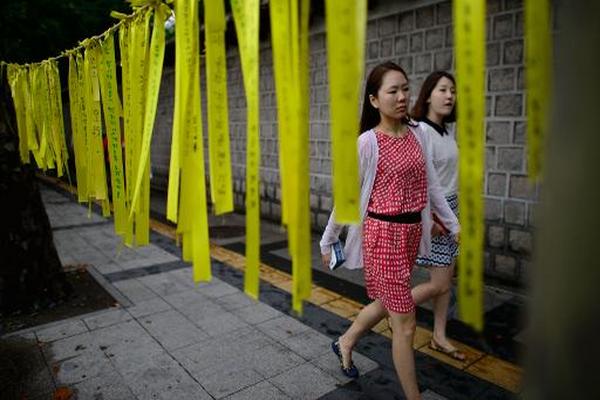 Cintas amarillas en memoria de las víctimas del naufragio del ferry 'Sewol', en una calle de Seúl. (Foto Prensa Libre: AFP).