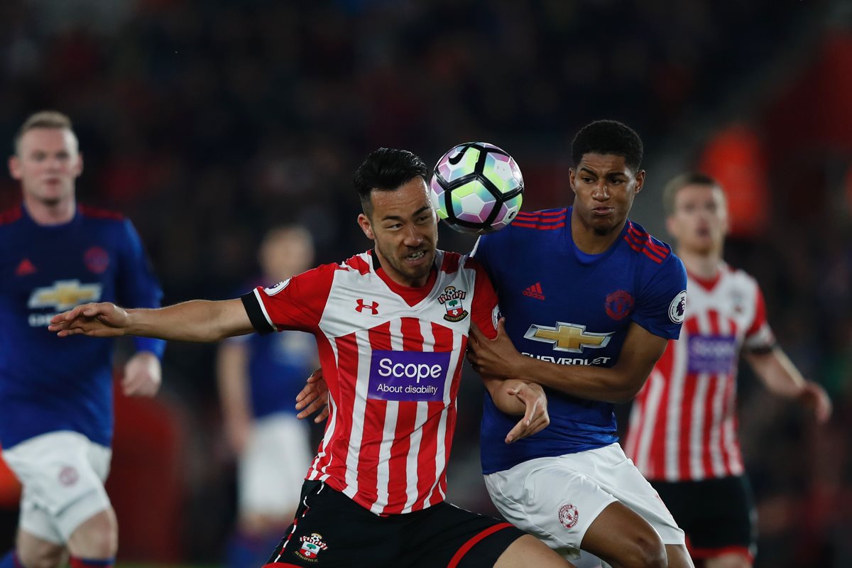 El delantero Marcus Rashford pelea por el balón con el japonés Maya Yoshida. (Foto Prensa Libre: AFP)