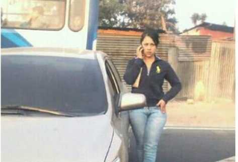 Heidy Véliz, con gesto de molestia, conversa por celular mientras esperan retire su carro.