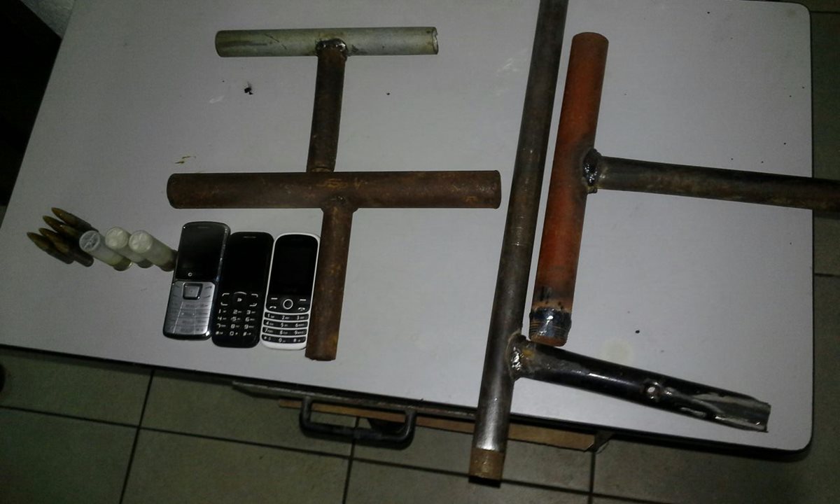 Escopetas y teléfonos fueron incautados a los tres sospechosos de extorsión. (Foto Prensa Libre: PNC)