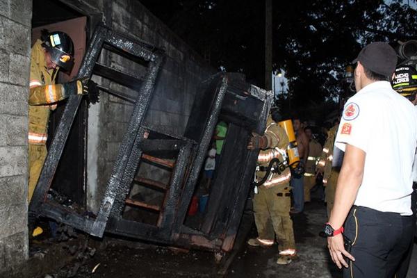 Rescatistas sacan restos de muebles de la vivienda que fue destruida por el fuego (Foto Prensa Libre: Rolando Miranda)<br _mce_bogus="1"/>