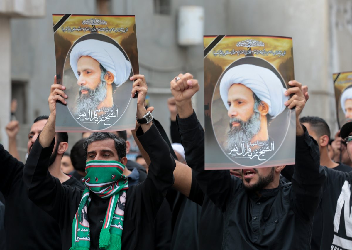 Chiíes saudíes sostienen pancartas con retratos del prominente clérigo musulmán chií Nimr al- Nimr durante la protesta. (Foto Prensa Libre: AFP).
