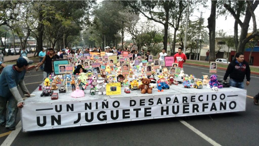 Varios juguetes fueron colocados en una plataforma en una curiosa marcha para denunciar desapariciones. (Foto Prensa Libre: Érick Ávila)