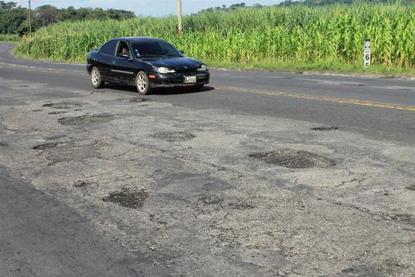 Conductores de Escuintla deben  guiar sus vehículos con precaución, en un tramo de 20 kilómetros, entre la cabecera y Siquinalá  para no accidentarse al caer en un bache. (Foto Prensa Libre: Enrique Paredes)