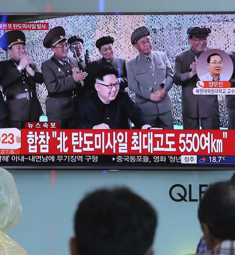 Norcoreanos ven frente una pantalla de televisión al líder norcoreano Kim Jong Un. (AP).