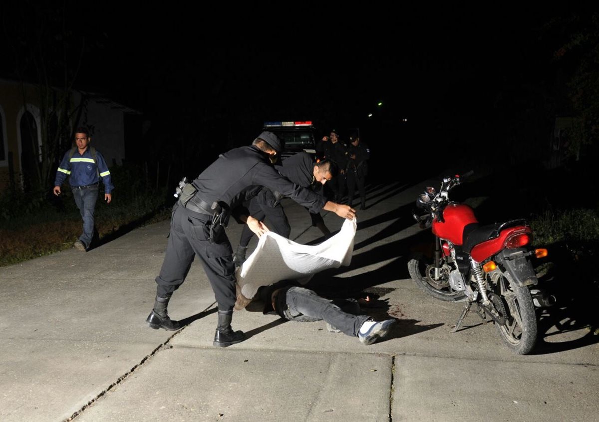 Agentes policiales cubren el cuerpo de Luis Emilio Chocooj Tiul. (Foto Prensa Libre: Rigoberto Escobar)