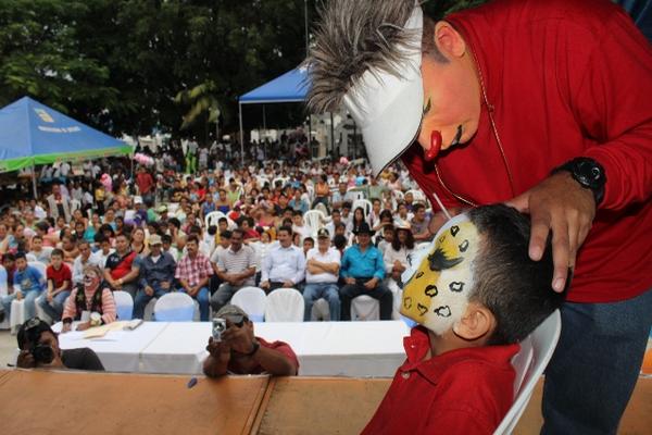 Uno de los payasos que participaron en el festival pinta la cara de un niño que asistió al festival. (Foto Prensa Libre: Óscar González)<br _mce_bogus="1"/>