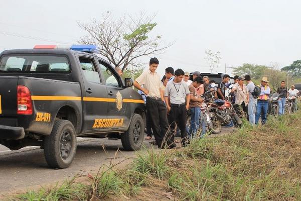 Curiosos observan el cadáver a la orilla de la carretera. (Foto Prensa Libre: Carlos Paredes)<br _mce_bogus="1"/>