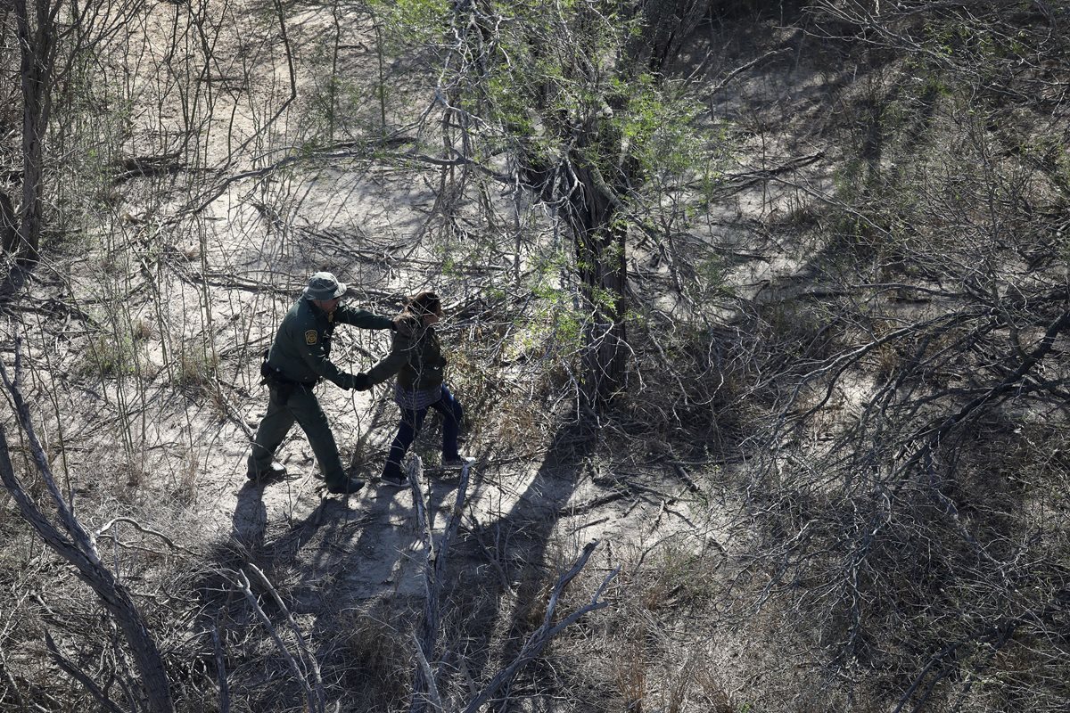 Un agente de la patrulla fronteriza de los EE. UU. detiene a un inmigrante indocumentado cerca de la frontera EE. UU.-México.(Foto Prensa Libre: AFP).