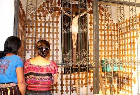 Mujeres observan las cruces de madera con el nombre de sus familiares desaparecidos durante el conflicto armado interno.
