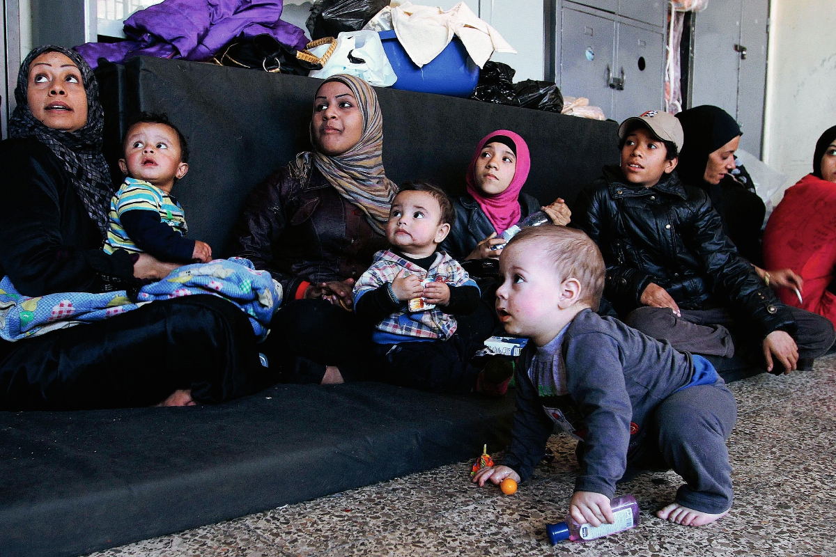 Palestinos que lograron escapar de Al Yarmuk esperan asistencia en una escuela de la capital siria, Damasco. (Foto Prensa Libre: AFP).