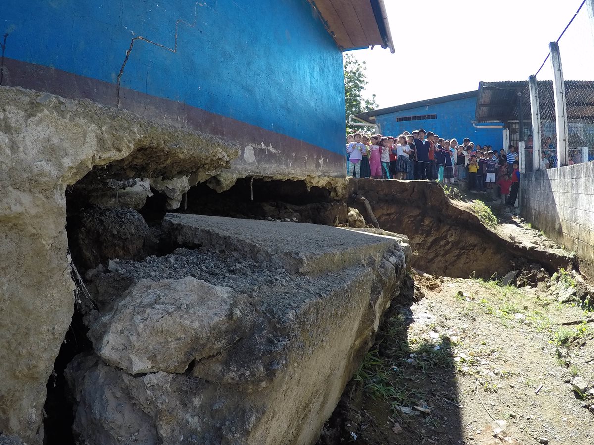 Niños observan el agujero que afecta a la escuela en San Pedro Carchá. (Foto Presa Libre: Eduardo Sam).