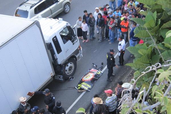 La PNC resguarda el cadáver y el camión comercial. (Foto Prensa Libre: Angel Julajuj)<br _mce_bogus="1"/>