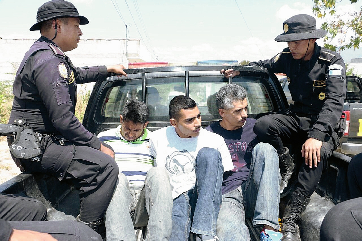 Los tres capturados son trasladados en un autopatrulla custodiados por dos agentes policiales, en Salamá. (Foto Prensa Libre: Carlos Grave)