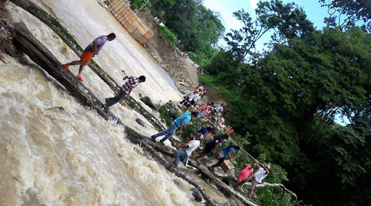 Personas usan ramas para cruzar el río Jubuco en aldea Natalia, Los Amates, izabal. (Foto Prensa Libre: Dony Stewart)