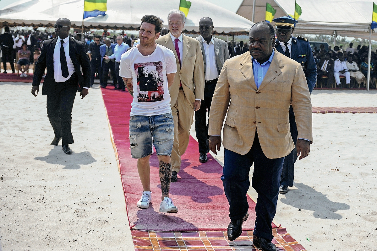 Lionel Messi durante el acto de inauguración del estadio Port-Gentil con el presidente Ali Bongo Ondimba. (Foto Prensa Libre: AFP)