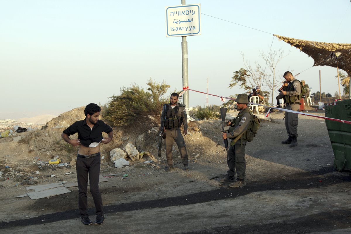 Soldados israelíes revisan a un palestino durante los enfrentamientos en los Territorios Palestinos. Foto Prensa Libre (AP)