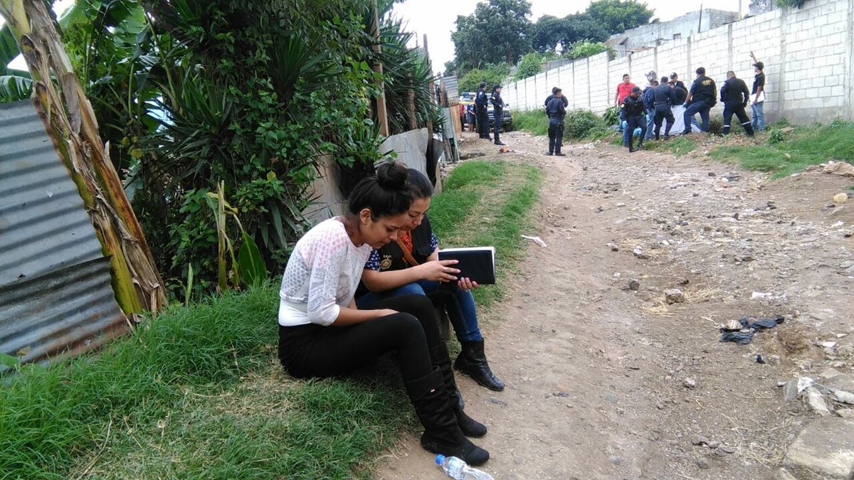 La conviviente de Kevin Alonzo reconoció el cuerpo, el cual es cubierto por investigadores del MP y agentes de la PNC, en Villa Nueva. (Foto Prensa Libre: Estuardo Paredes)