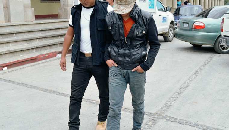 Agente de la Policía custodia a presunto extorsionista, en la ciudad de Quetzaltenango. (Foto Prensa Libre: Alejandra Martínez)