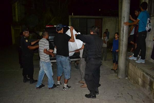 Agentes de la PNC traslada el el cadáver de Nixon Oswaldo Mejía Reyes hacia la morgue del Inacif de Guastatoya, El Progreso. (Foto Prensa Libre: Hugo Oliva)