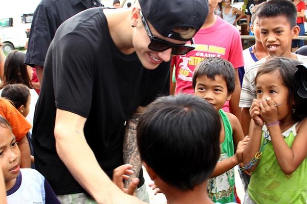 Justin Bieber comparte con algunos niños que sobrevivieron al tifón Haiyan. (Foto Prensa Libre: AP)