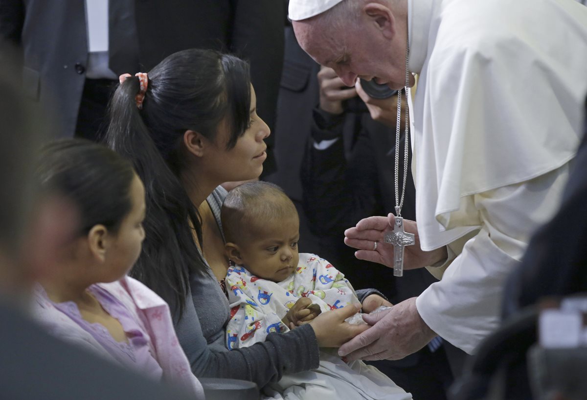 El papa Francisco saluda a un niño enfermo que está junto a su madre durante la visita al hospital Federico Gómez. (Foto Prensa Libre: AP).