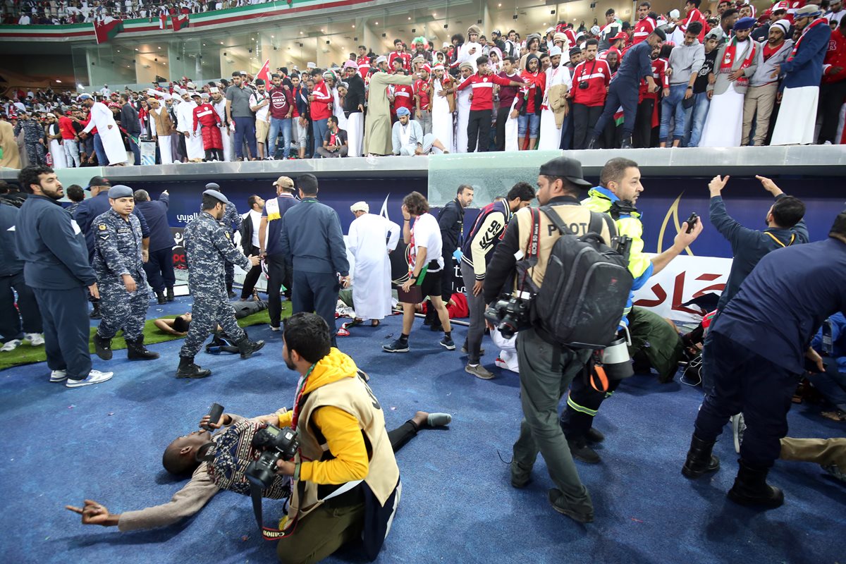 La caída de la barrera provocó que varios aficionados cayeran en una de las bancas. (Foto Prensa Libre: AFP)