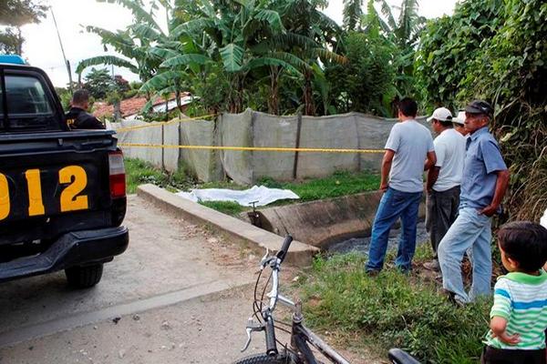 Un grupo de vecinos observa el cadáver de Fael Mazariegos, quien era encargado de la Hidroeléctrica Municipal de San Jerónimo. (Foto Prensa Libre: Carlos Grave).  