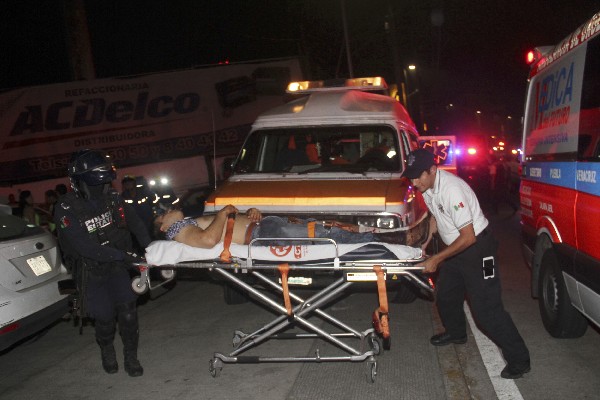 Paramédicos auxilian a un herido a después de una balacera en Xalapa,Veracruz.(EFE).