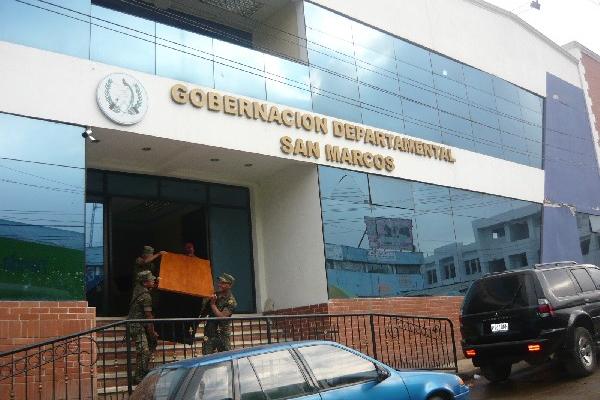 Soldados trasladan mobiliario.