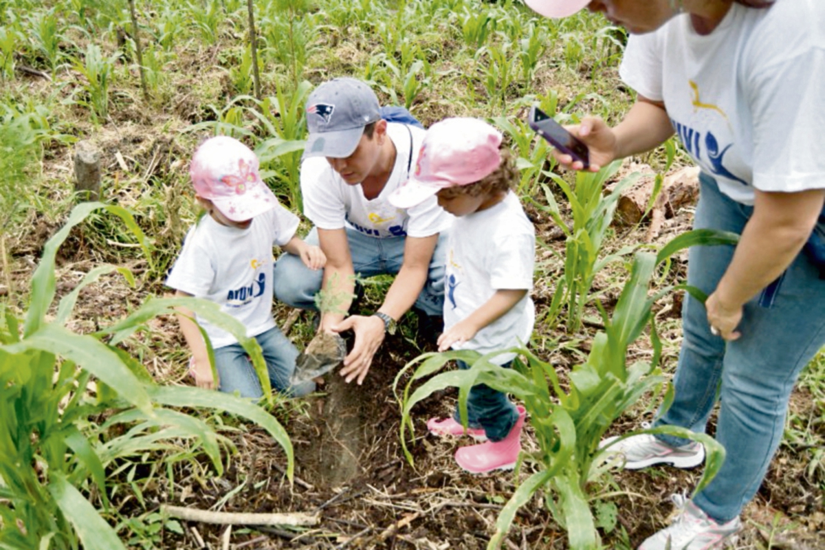 Dos niños  siembran un árbol, durante una  jornada de reforestación en Salamá, Baja Verapaz.