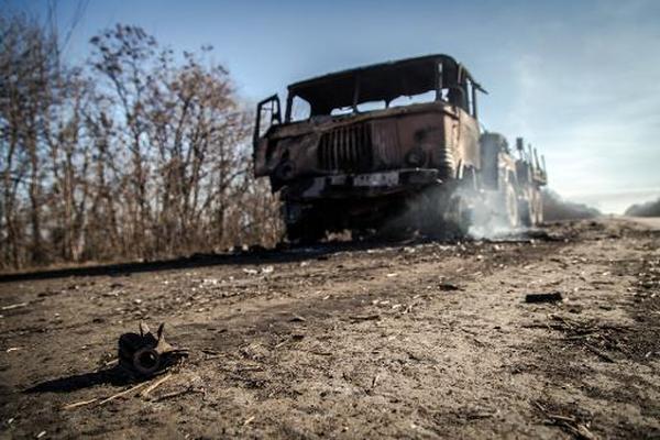 Dos camiones quemados de las fuerzas ucranianas en una carretera cerca  de Luganske, en la región de Donetsk. (Foto Prensa Libre: AFP)