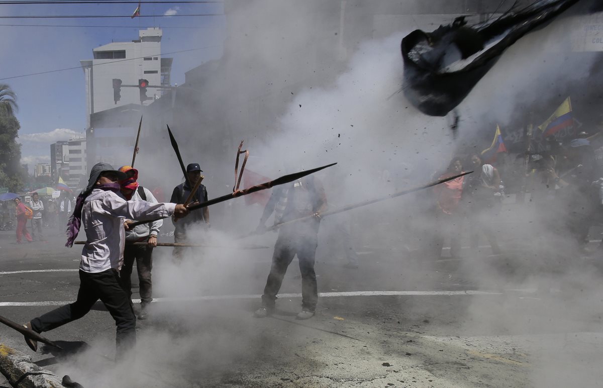Manifestantes lanzan objetos a la Policía, en Quito. (Foto Prensa Libre: AP).