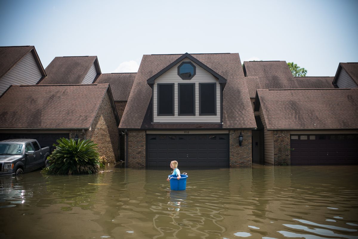 Jenna Fountain lleva un cubo para intentar recuperar los artículos de su hogar inundado Port Arthur, Texas. Los residentes de Houston y otras ciudades de Texas comenzaron a regresar a casa para evaluar los daños causados por el huracán Harvey.(Foto, Prensa Libre: AFP)