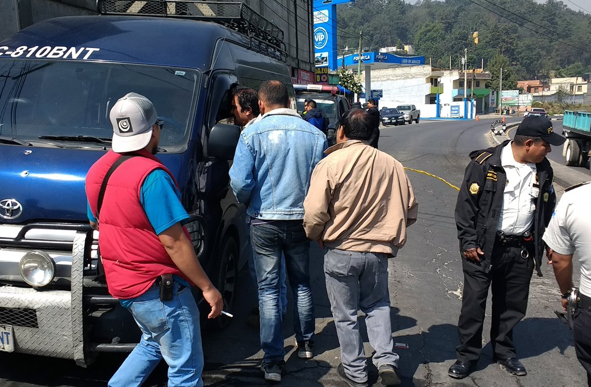 Curiosos permanecen junto al microbús que fue atacado a balazos en la ruta entre Xela y San Juan Ostuncalco. (Foto Prensa Libre: Carlos Ventura).