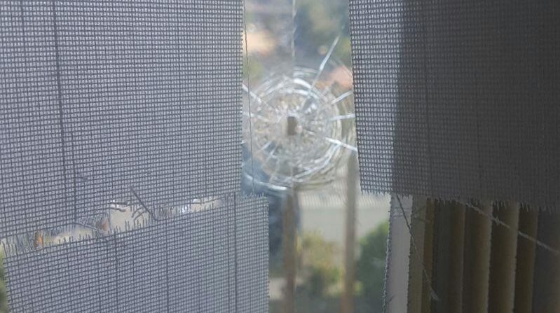 Una de las ventanas ubicadas en la redacción de Canal Antigua resultó con daños debido al proyectil de arma de fuego. (Foto Prensa Libre:)
