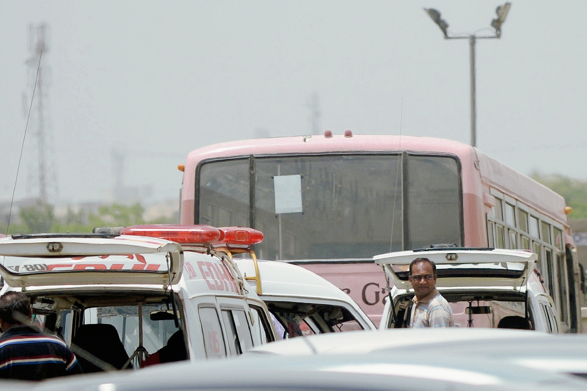 Un grupo paquistaníes están cerca del autobús que fue ataque por hombres armados en Karachi. (Foto Prensa Libre:AFP)