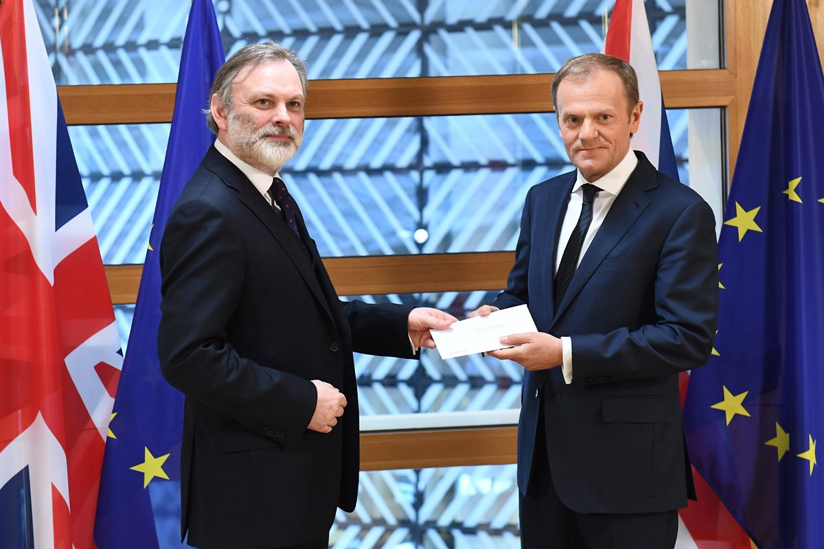 Embajador británico Tim Barrow entrega la carga que oficializa la salida del Reino Unido de la Unión Europea al presidente del concejo Donald Tusk. (Foto Prensa Libre: AFP)