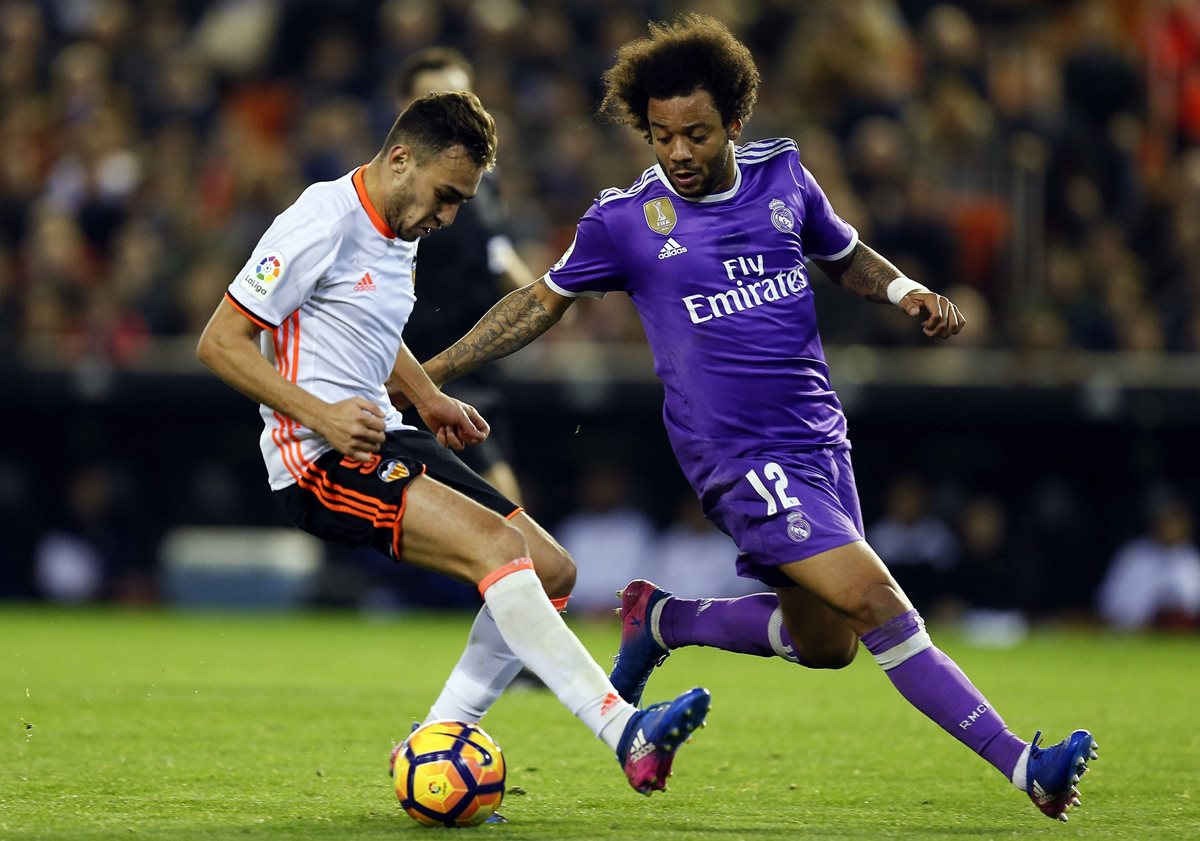 El delantero del Valencia Munir El Haddadi (i) disputa un balón con el defensa brasileño del Real Madrid Marcelo. (Foto Prensa Libre: EFE)