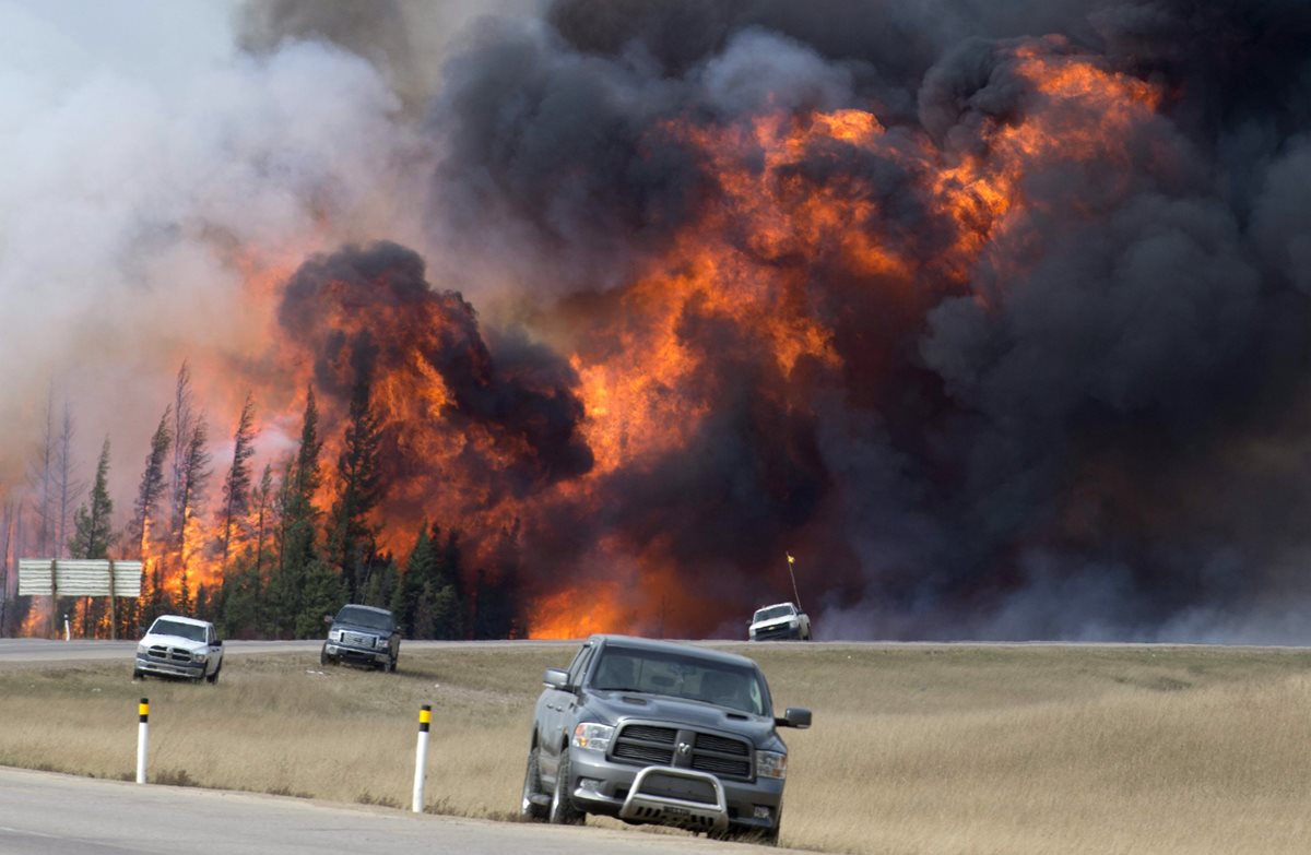 Habitantes de Fort McMurray continúan huyendo del enorme incendio que cada minuto crece más. (Foto Prensa Libre: AP).
