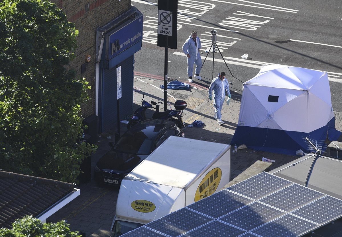 Dos policías forenses trabajan junto a la furgoneta, tras el ataque perpetrado con un vehículo cerca de la mezquita de Finsbury Park, en Londres. (Foto Prensa Libre: EFE)