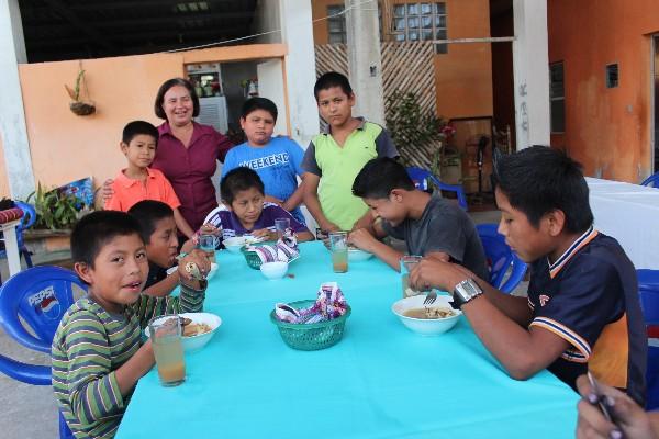 Susana Reyes —doña Susy, como se le conoce—  acompaña a varios  niños lustradores, a quienes apoya con su programa de alimentos y educación, en Poptún, Petén.