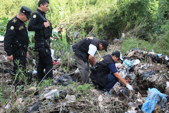 Fiscales del Ministerio Público trabajan en el área donde fue encontrado el cuerpo del menor. (Foto Prensa Libre: Óscar González)